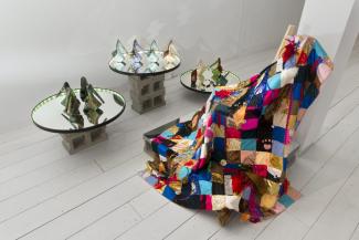 installation view of quilt, and ceramics shoes on a mirror platform installed in a gallery