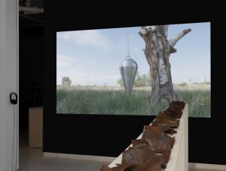 a video of a pendulum hanging from a tree, the projection framed by a dark wall, with a row of steel plates on a shelf