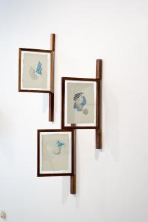 Installation view of framed drawings installed perpendicular to the wall