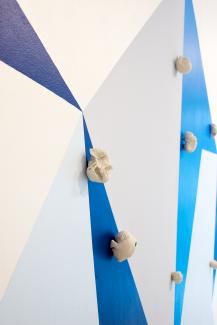 wall painting of geometric shapes in various blue tones, with ceramic sculptural objects