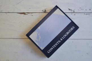 image of cardboard box which reads "contents: 8 logbooks"