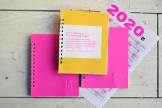 image of two pink and one yellow spiral bound notebooks and 2020 calendar