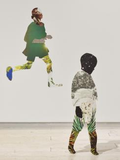 Installation of collaged work on the wall and extending into the space as 2D sculptures, featuring a small child standing, with a child running behind them