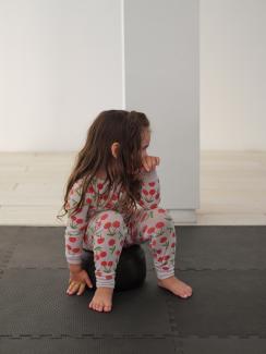 Image of a long-haired child in cherry-print pyjamas sitting on Carrie Allison's BIG BEADZ while watching a projected video.