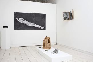 installation view of photographs and sculptures in a gallery space