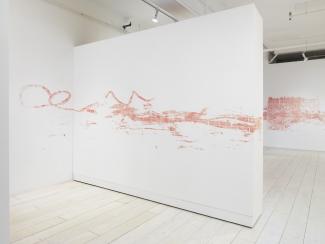 installation view of a stencilled drawing in pink chalk