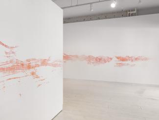 installation view of a long stencilled drawing in pink chalk
