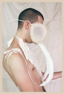 A photograph of a profile of a person wearing a white fanged apparatus obstructing their face