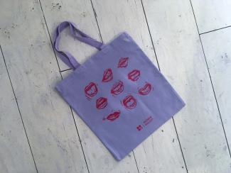 lavender tote bag with image of 9 mouths in a grid printed in red in