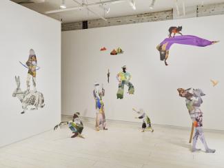 Installation of collaged work on the wall and extending into the space as 2D sculptures, featuring human and animal figures.