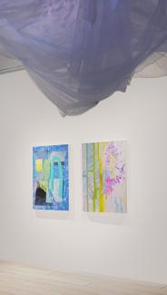 Two brightly coloured paintings in blues and yellows on a white wall. In the foreground, white netting hangs from above on which violet light is projected.