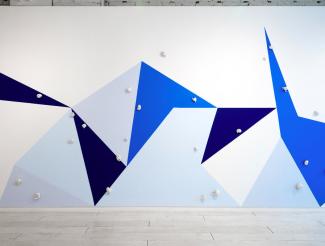 image of a large mural of traingular shapes in various shades of blue and white.