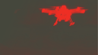 A dark grey-green background with a blurry red silhouette of a quadcopter drone. 