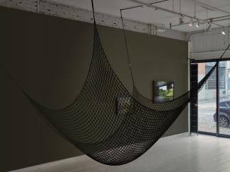 A cargo net, part of Serena Lee's sound installation, is suspended in the centre of the gallery. 