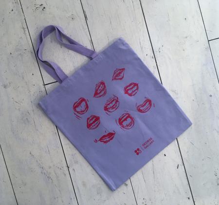 lavender tote bag with image of 9 mouths in a grid printed in red in
